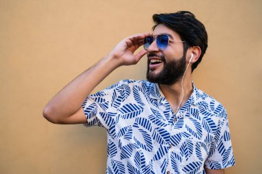 Genç adam kulaklıkla müzik dinliyor..