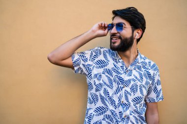 Genç adam kulaklıkla müzik dinliyor..