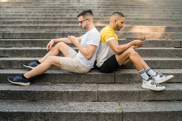 Pareja gay ignorándose mutuamente mientras usa sus teléfonos. —  Fotos de Stock