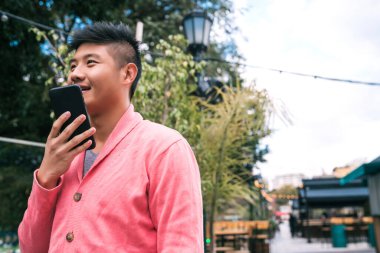 Asyalı bir adam sesli mesaj gönderiyor..