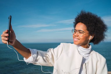 Telefonla selfie çeken genç bir kadın..