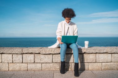 Dizüstü bilgisayarını kullanan genç bir kadın..