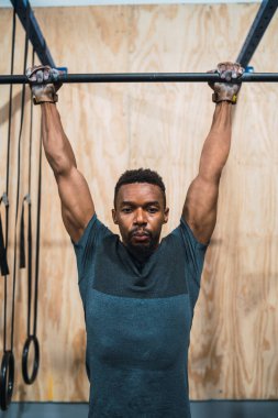 Sporcu adam spor salonunda egzersiz yapıyor..