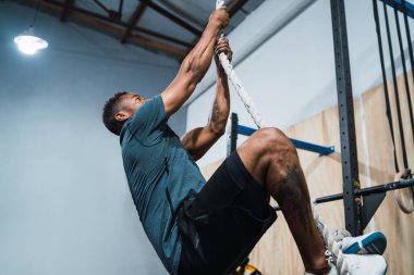 Atletik adam tırmanma egzersizi yapıyor..