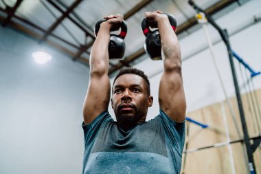 Atletik adam Crossfit kettlebel ile egzersiz yapıyor..