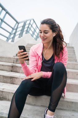 Atletik kadın telefonunu kullanıyor..