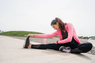 Sporcu kadın egzersizden önce bacaklarını açıyor..