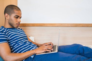 Evde dizüstü bilgisayar kullanan bir Latin..