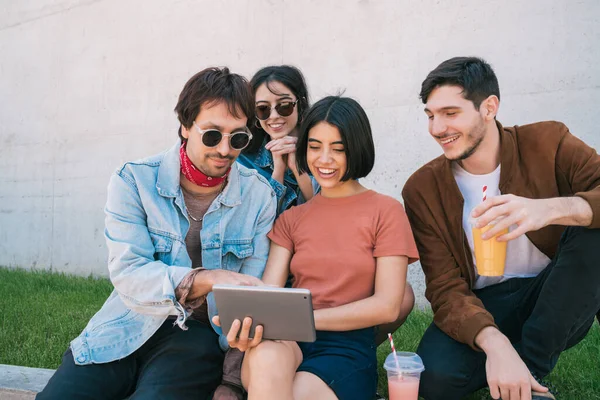 Amigos usando tablet digital juntos ao ar livre. — Fotografia de Stock