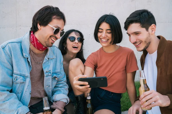 Gruppe von Freunden schaut etwas im Smartphone. — Stockfoto