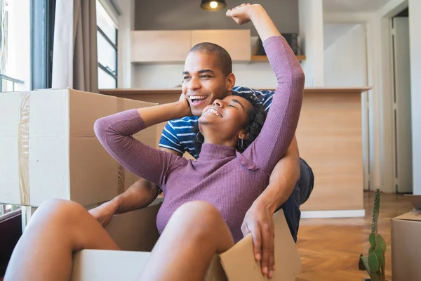 Coppia latina si diverte con scatole di cartone in una nuova casa. — Foto Stock