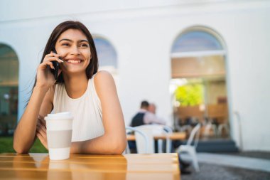 Genç Latin kadın telefonda konuşuyor..