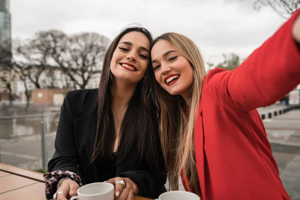 Dois jovens amigos tirando uma selfie juntos no café. — Fotografia de Stock