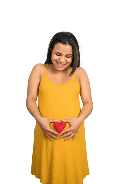 Donna incinta che tiene il segno del cuore sulla pancia. — Foto Stock