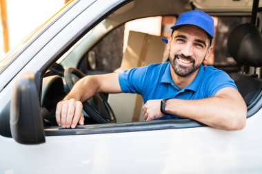Karton kutularla dolu bir minibüs taşıyan teslimatçı..