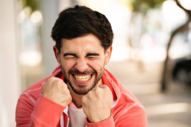 Genç adam dışarıda zaferi kutluyor..