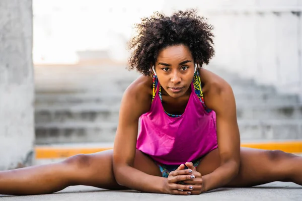 Afro sportoló nő nyújtás láb edzés előtt. — Stock Fotó