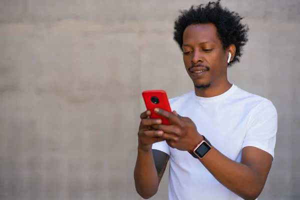 Friidrott man använder sin mobiltelefon utomhus. — Stockfoto