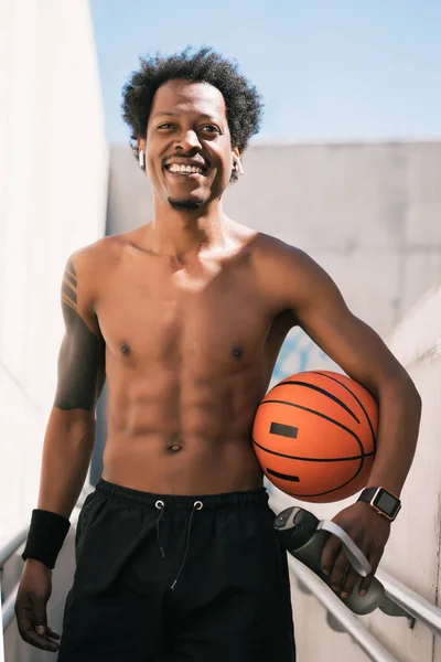 Afro idrottare man som håller en basket boll utomhus. — Stockfoto