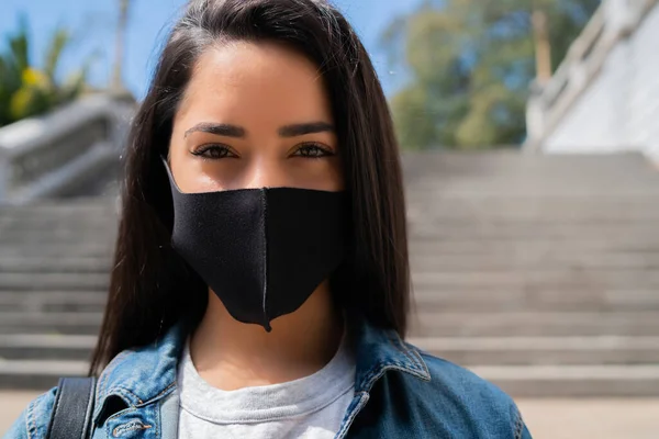 Mujer joven con máscara protectora al aire libre. — Foto de Stock