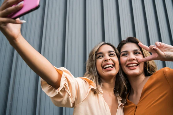 Dois amigos tomando selfie com telefone ao ar livre. — Fotografia de Stock