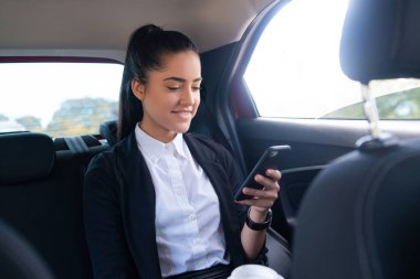 İş kadını arabada cep telefonu kullanıyor..