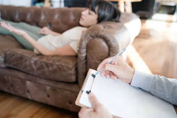 Psycholoog maakt aantekeningen tijdens therapiesessie. — Stockfoto