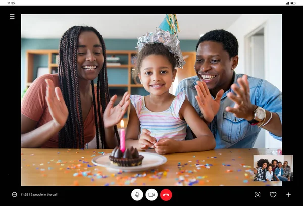 Family celebrating birthday on a video call.