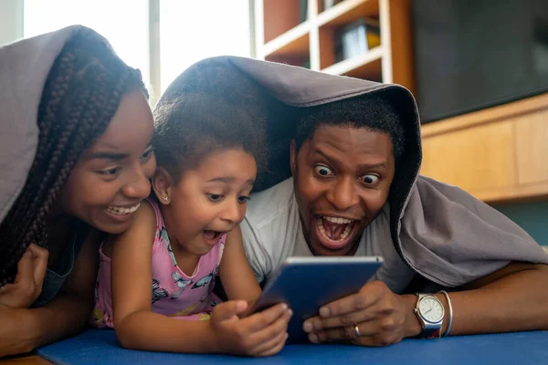 Famille utilisant une tablette numérique à la maison. — Photo