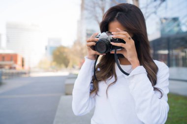 Profesyonel kamera kullanan genç bir kadın..