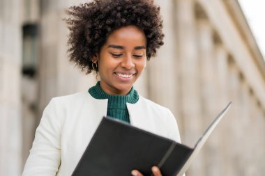 Afro iş kadını elinde bir pano ile sokakta bekliyor..