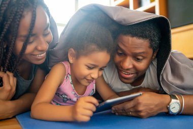 Evde dijital tablet kullanan aile.