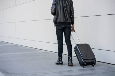 Dışarıda yürürken bavul taşıyan bir turist..