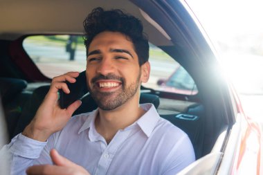 İş adamı arabada telefonla konuşuyor..