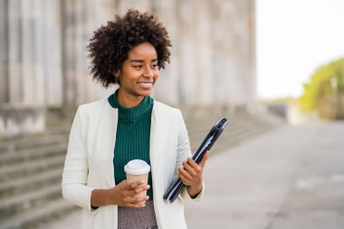 Afro iş kadını sokakta yürüyor..