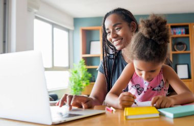 Ev okulunda kızına yardım eden bir anne..