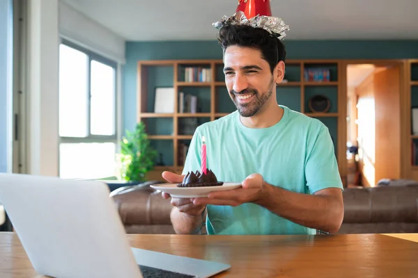 Man celebrating birthday online from home.