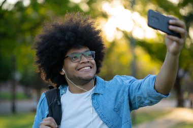 Latin adam dışarıda telefonla selfie çekiyor..