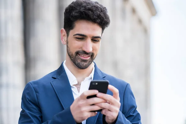 Business man using his mobile phone outdoors.
