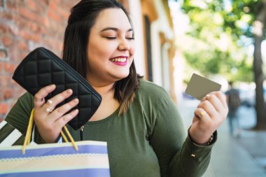 Genç bir kadın kredi kartıyla alışveriş yapıyor..