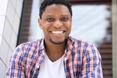 Afro-Amerikalı bir adam mağazanın vitrininde oturuyor..