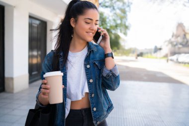 Dışarıda telefonla konuşan genç bir kadın..