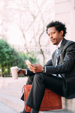 İş adamı cep telefonunu açık havada kullanıyor..