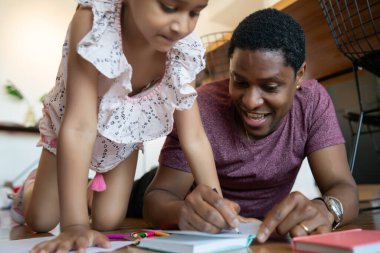 Baba ve kızı evde birlikte oynuyorlar..