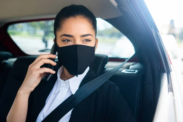 Businesswoman talking on phone in car.