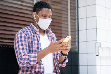 Sokakta telefonunu kullanan bir adam..