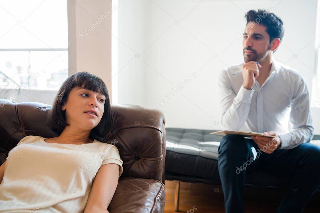 Psychologist taking notes during therapy session.