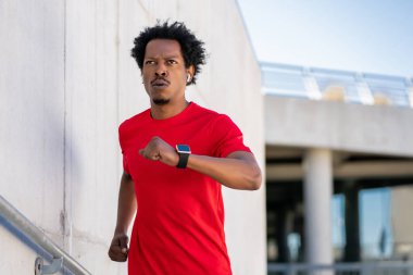 Atletik adam koşuyor ve dışarıda egzersiz yapıyor..