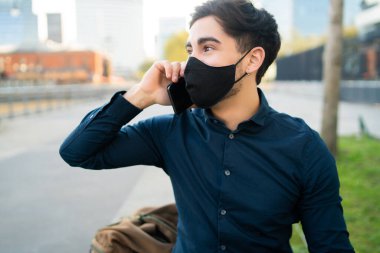 Genç adam dışarıda telefonla konuşuyor..