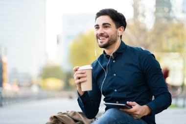 Genç adam dışarıda dijital tablet kullanıyor..